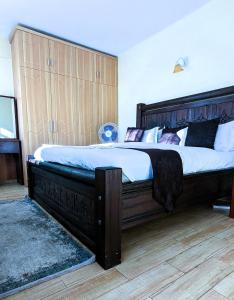 内罗毕Tribal Themed 3BR Penthouse的卧室内的一张带木制床头板的大床
