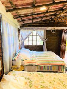 卡哈马卡Cabaña Kinti Yuraq en Kinti Wasi的一间卧室设有两张床和窗户。