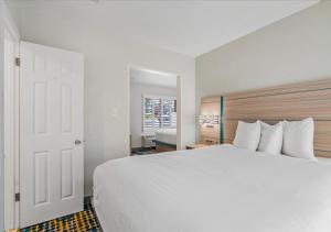 莫罗贝太平洋海岸旅馆 - 莫罗湾的卧室设有一张白色大床和一扇窗户。