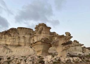 马萨龙港SunRise Den, a pie de playa, vista al mar y piscina的沙漠中的岩石在云天下形成