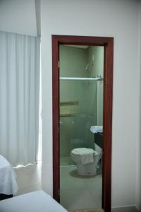阿拉皮拉卡hotel quatro coracoes的一间带卫生间和玻璃淋浴间的浴室