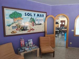 庞特维德拉Camping Sol y Mar的墙上有画作的房间和桌子