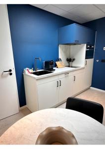 韦默尔丁厄Hotel Brasserie Smits的厨房设有水槽和蓝色的墙壁