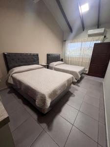 圣克鲁斯Casa bonita y cómoda的客房设有两张床和窗户。