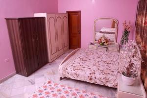卡拉奇Regal Palace Gulshan Nipa的粉红色的卧室配有床和镜子