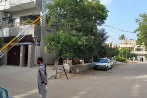 卡拉奇Regal Palace Gulshan Nipa的一个人沿着建筑物旁边的街道走