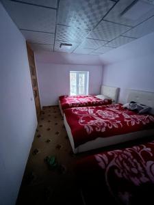 Bagu HOMESTAY的一间卧室设有两张床和窗户。
