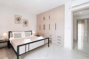 阿凯松Zante Luxury Apartment的白色卧室设有一张大床和一个梳妆台