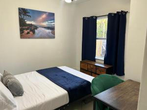 西棕榈滩Private Rooms in West Palm Beach - Next to Airport的一间卧室配有一张床、一张桌子和一个窗户。