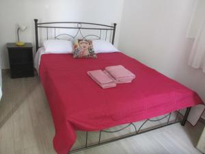 KarpásionKarpasi House的一张带红色毯子和两条毛巾的床