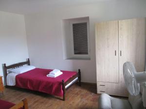 KarpásionKarpasi House的一间卧室配有一张带红色毯子的床