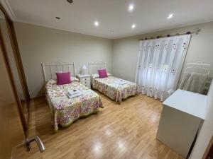 雷东德拉Casa Costeira的一间客房内配有两张床的房间