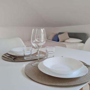 圣焦万尼泰亚蒂诺Gate 25的一张带盘子和玻璃杯的白色桌子