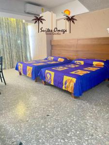 阿卡普尔科Suites Omega Torres Gemelas的配有两张蓝色和黄色床单的客房