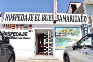帕拉卡斯Hospedaje El Buen Samaritano的白色的建筑,前面有标志