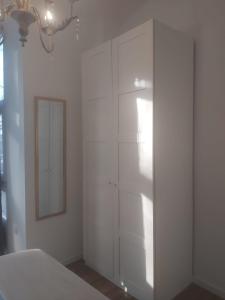 费罗尔Buhardilla en el Cantón的白色卧室配有衣柜和镜子