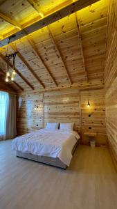 杜拉特阿拉尔درة العروس اكواخ الدره的木制客房内的一间卧室配有一张大床