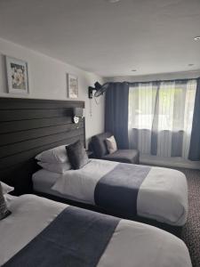 曼彻斯特Posyrooms的酒店客房,配有两张床和椅子