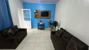 伊瓜苏Casa do aconchego ( terreno compartilhado)的客厅配有两张沙发和一台电视机