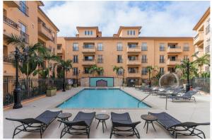 洛杉矶Modern 2bedroom Apartment with Pool的一座带椅子的游泳池以及一座建筑
