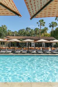 圣地亚哥拉霍亚埃斯坦守Spa酒店的度假村的游泳池,配有椅子和遮阳伞
