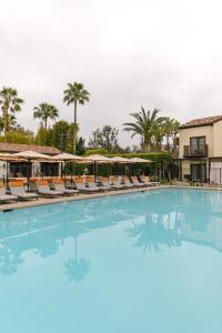 圣地亚哥拉霍亚埃斯坦守Spa酒店的度假村的游泳池配有椅子和遮阳伞