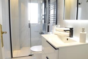 马德里Bonito Apartamento Madrid Rio的白色的浴室设有水槽和淋浴。