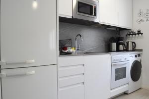 马德里Bonito Apartamento Madrid Rio的厨房配有白色橱柜、洗衣机和烘干机