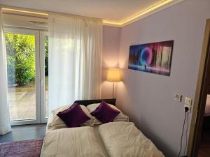圣路易Charming apartment with Garden, Free Parking near Basel, Airport, Ger'many, France,的卧室配有一张带紫色枕头的床,毗邻窗户