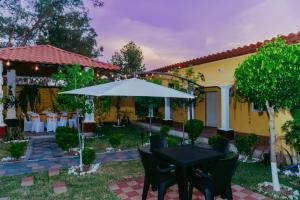 韦韦特南戈Conceptos Campestre的一个带桌子和遮阳伞的庭院