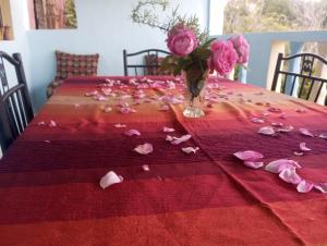 Aïn BouchrikDar Lala Zhour的一张带粉红色玫瑰和花瓶的桌子