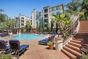 洛杉矶Cute Santa Monica Apartment with Pool的一座带躺椅的游泳池以及建筑