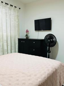 麦德林Hospedaje juandi的一间卧室配有一张床和一台平面电视