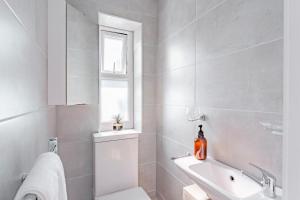 伦敦Cosy & Stylish Apmt w/ Fast Wifi的一间带卫生间、水槽和窗户的浴室