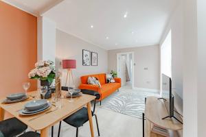 伦敦Cosy & Stylish Apmt w/ Fast Wifi的客厅配有橙色沙发和桌子