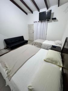 圣克鲁斯Acogedor independiente-Casa JH B的配有两张床铺的客房,墙上配有电视