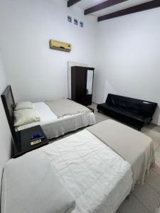 圣克鲁斯Acogedor independiente-Casa JH B的白色客房的两张床,配有镜子