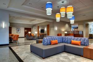 克拉尔维尔Drury Inn & Suites Iowa City Coralville的大堂配有沙发和桌椅