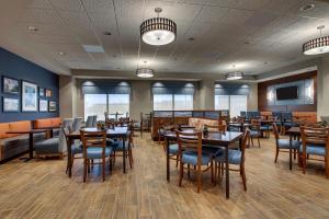 克拉尔维尔Drury Inn & Suites Iowa City Coralville的用餐室配有木桌和椅子