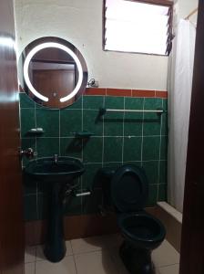 HuamboyaDEPARTAMENTO completo cercano a muchos lugares的浴室设有黑色的卫生间和水槽。
