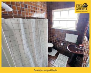 布卢梅瑙Casa Amarela Blumenau Hospedagem Alternativa的一间带卫生间和淋浴帘的浴室