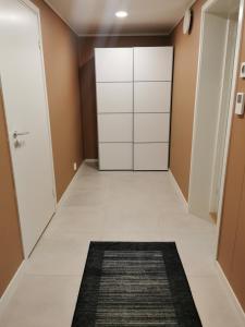 斯沃尔韦尔Svolvær Apartment, Vestermyrveien 11的走廊上设有白色衣柜和黑色地毯