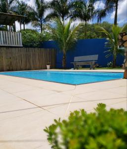 卡皮托利乌Pousada Recanto Rainha do Lago的一个带长凳和棕榈树的游泳池