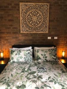 亚勒旺加Sailz Villas的一间卧室配有一张带两个枕头和一面墙的床。