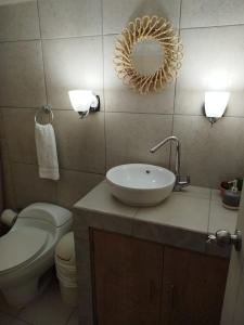 危地马拉Urban Home的一间带水槽、卫生间和镜子的浴室