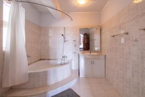 明德卢Maya Apartments的带浴缸、淋浴和盥洗盆的浴室