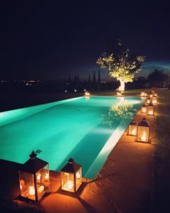 ContignanoDimora Buonriposo Pienza Country House的游泳池在晚上点亮,灯光照亮