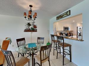 圣徒皮特海滩Ocean Sands 1002的用餐室以及带玻璃桌和椅子的厨房