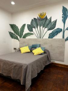 卢汉德库约JURAMA的一间卧室配有黄色和蓝色枕头的床