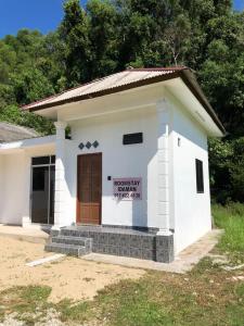 瓜拉丁加奴Tiny House Idaman Kuala Terengganu with Private House的一座白色的小建筑,上面有标志